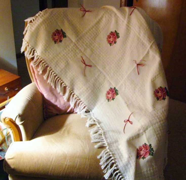 Handmade afghan with roses and bows.